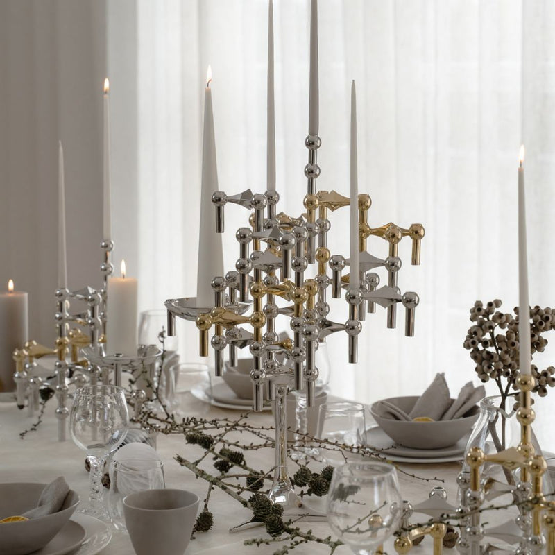 Elegant table setting with decorative candle holders and white tablecloth.