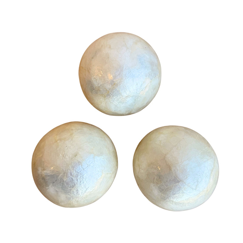 Three round ivory-colored capiz shell decorative balls are displayed against a white background. Each ball has a subtle, natural pattern and a glossy finish.