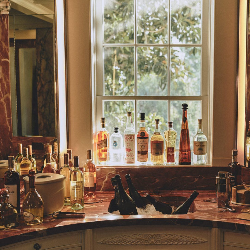 Styled bar side with bottles and Cast Aluminium Ice Bucket Maris by Kelly Wearstler x Giobagnara