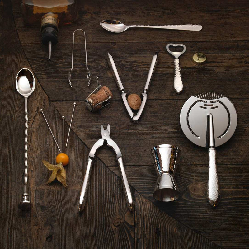 Collection of bar tools and Champagne tongs Martelé silver-plated by Robbe & Berking on a wooden surface