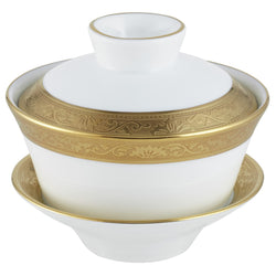 A white and gold colored Chinese tea cup with a gold rim and inlaid details, part of the Ambassador collection by Raynaud.