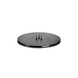 A round, matte black candle plate holder with three spikes on the top, designed to hold a candle securely.