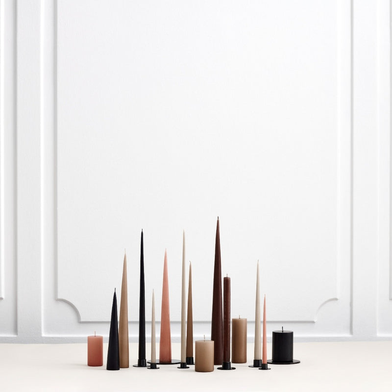 Set of tall, thin candles in various colors on a white background