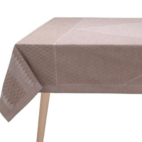 Beige patterned tablecloth on a wooden table with a white background