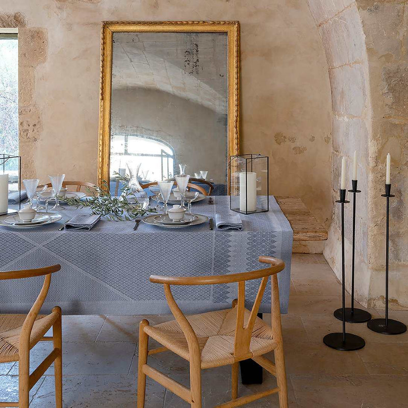 Dining table set with chairs in a rustic room with large mirror on the wall.