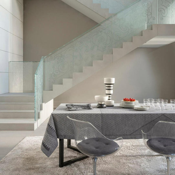 Modern dining area with a glass staircase in the background
