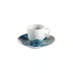 White porcelain cup and saucer with blue abstract design on a white background