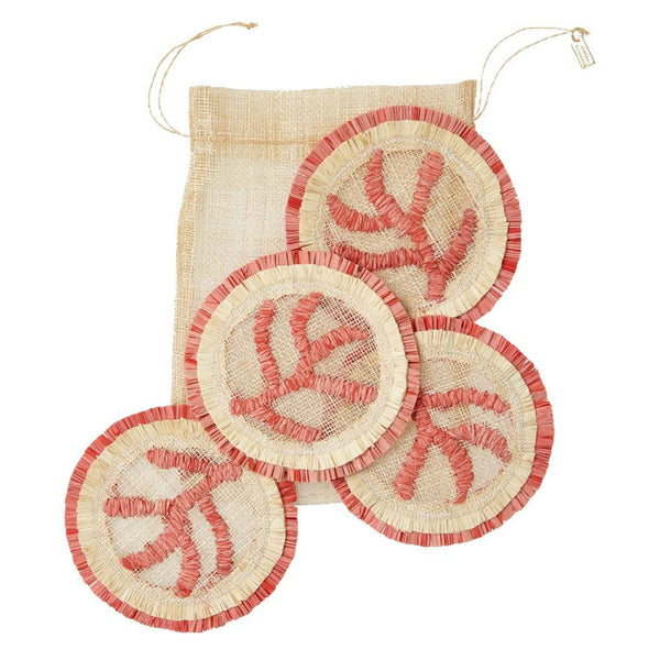 Set of three round woven coasters with red accents on a beige bag.