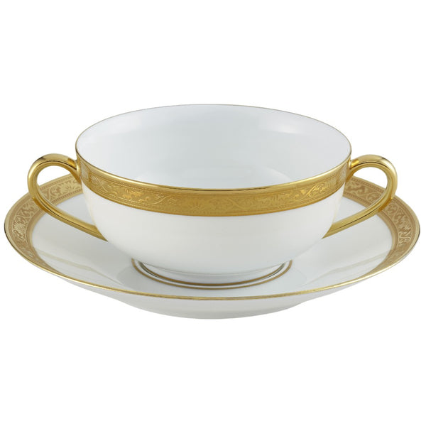 A white porcelain soup cup with gold Renaissance style border inlaid with fine gold details, accompanied by a matching gold rimmed saucer.