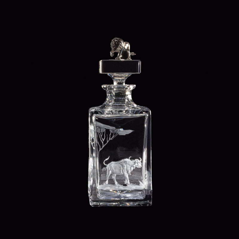 Crystal decanter with engraved buffalo design on a black background