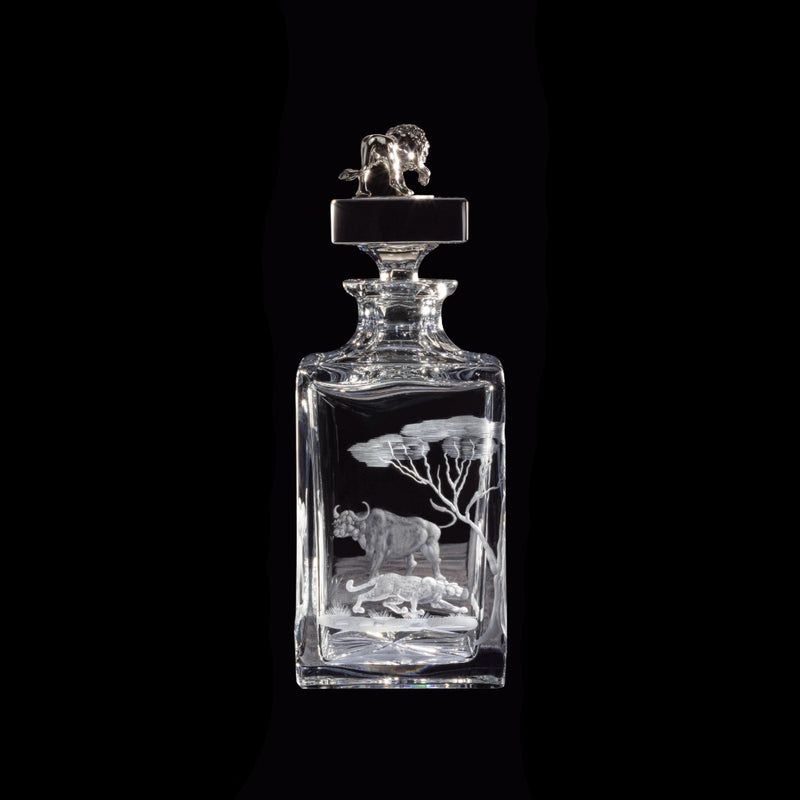 Decorative glass decanter with leopard and buffalo engravings on a black background