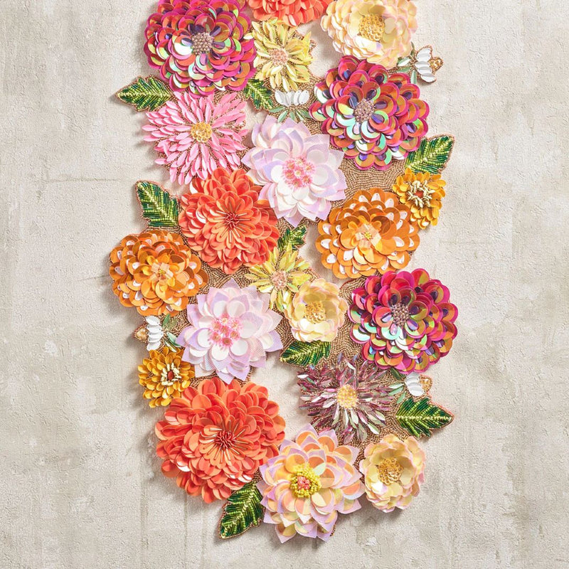 close-up of a flower pattern table runner in orange and pink sparkling beads