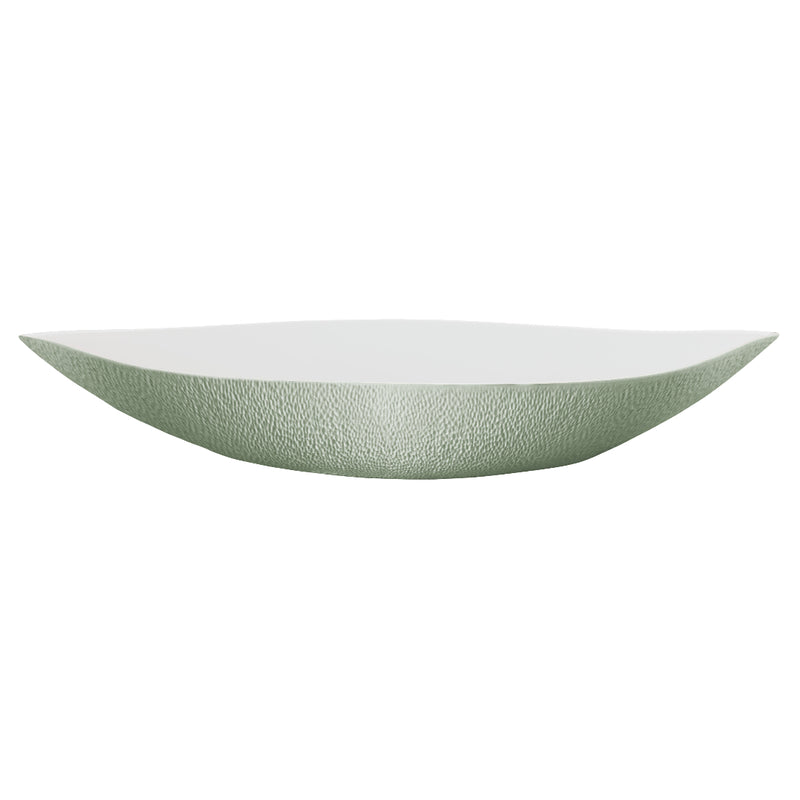 An elongated round white porcelain deep dish with a greenishceladon edge and interior, with a matte finish.