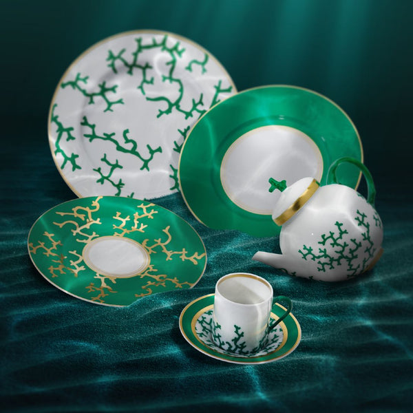 Porcelain Cristobal Emelard set with green and white patterns on a textured teal surface