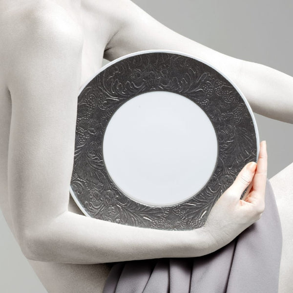 Person holding a dinner plate italian renaissance platinum by Raynaud against a neutral background