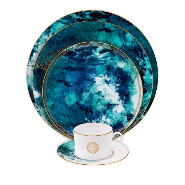 Teal marbled dinnerware set with a matching teacup and saucer on a white background