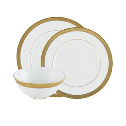 A set of white and gold porcelain dinnerware, including dinner plates, dessert plates, and soup bowls, with gold borders and rims.