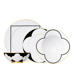 Set of black and white dinnerware with gold accents on a white background
