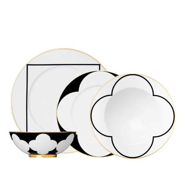 Set of black and white dinnerware with gold accents on a white background