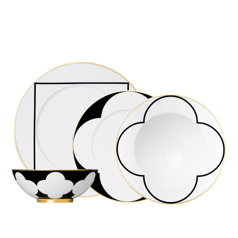 Set of black and white dinnerware with gold accents on a white background