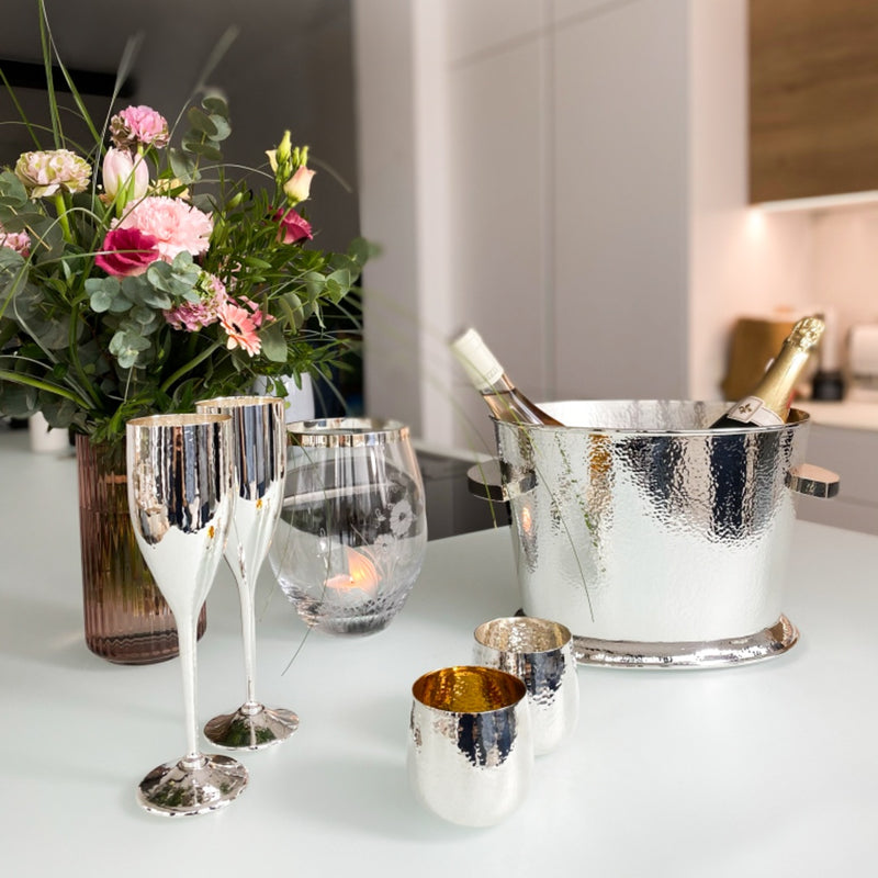Styled table with Double champagne cooler in hammered silver-plated finish by Sonja Quandt, holding two bottles