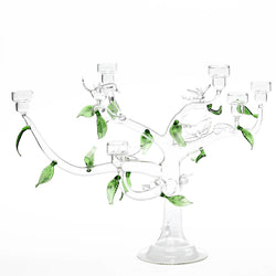 Clear glass candelabra with green leaves on a white background