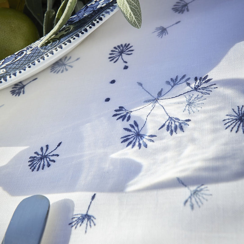 close-up of white tablecloth with blue flowers embroidered