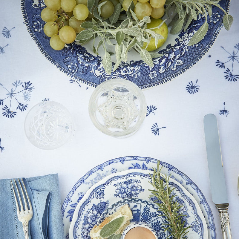 white tablecloth with blue small flowers featuring plates with grapes