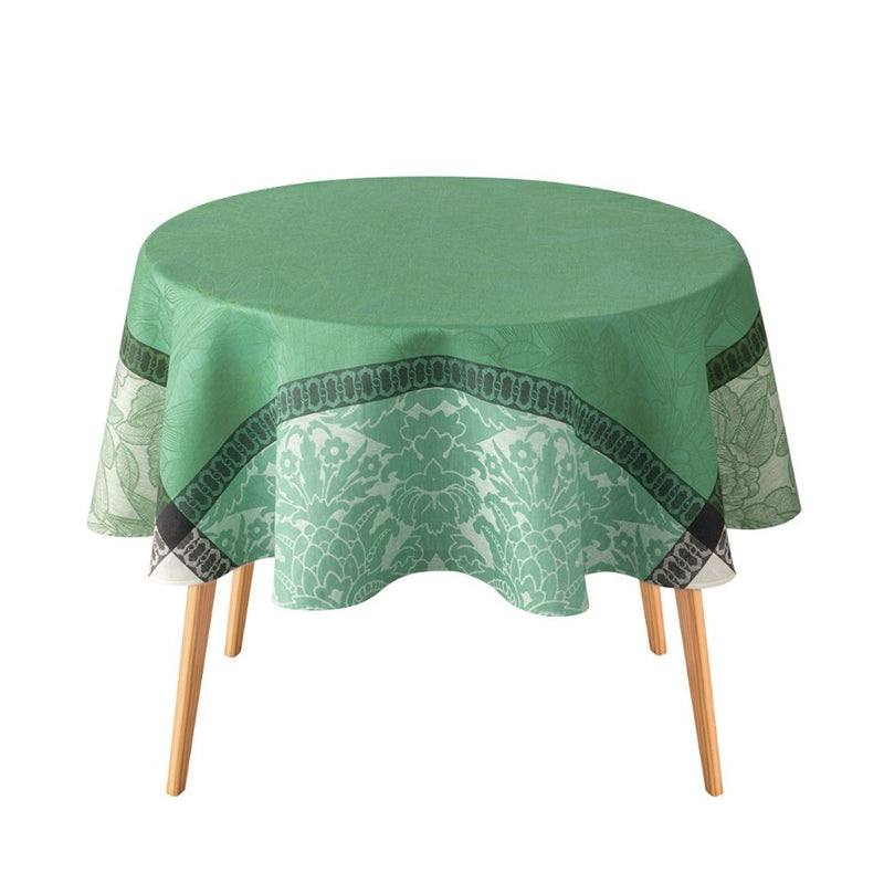 Green round tablecloth with a pattern on a wooden table