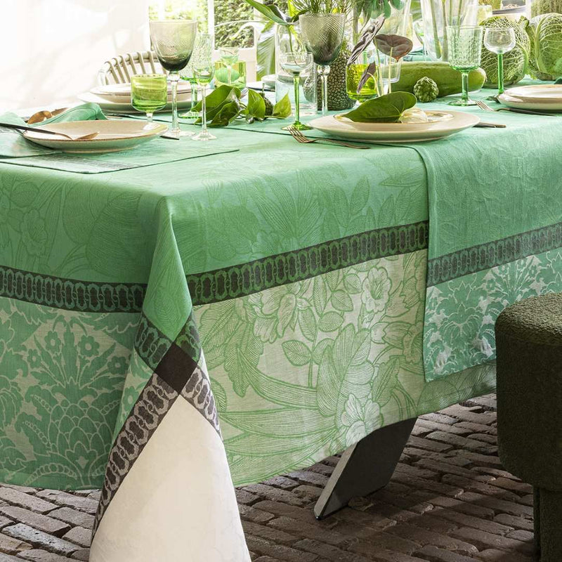 Decorative green tablecloth with floral pattern on a table set for a meal.