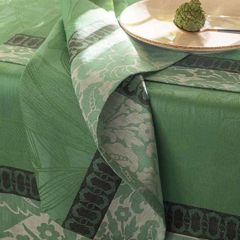 Green patterned fabric with decorative border on a tablecloth