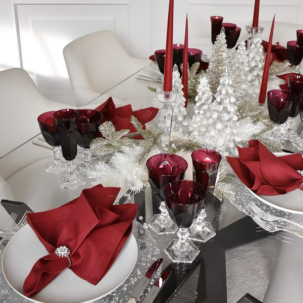 Decorative table setting with red and silver accents on a white table.