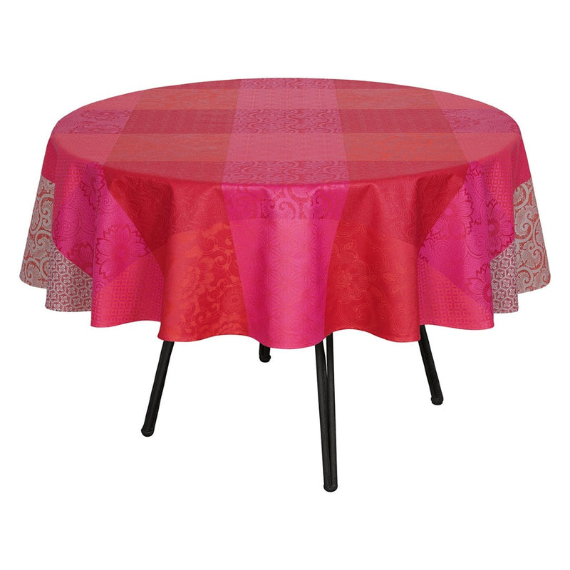 Round table with a pink and red checkered tablecloth on a white background
