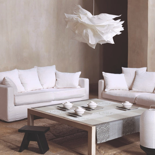 Modern living room with white sofas, a coffee table, and decorative elements.