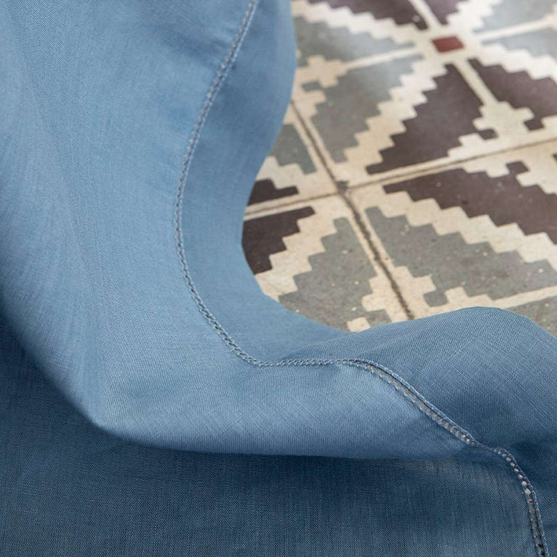 Close-up of blue fabric with a geometric pattern in the background