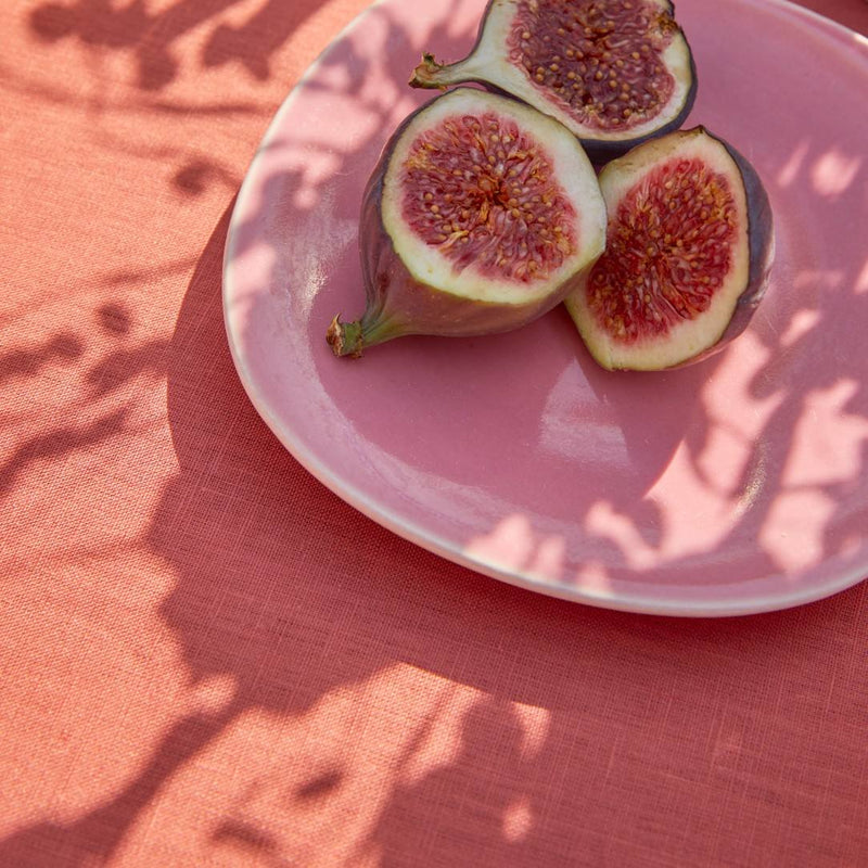 Sliced figs on a pink plate with a pink background