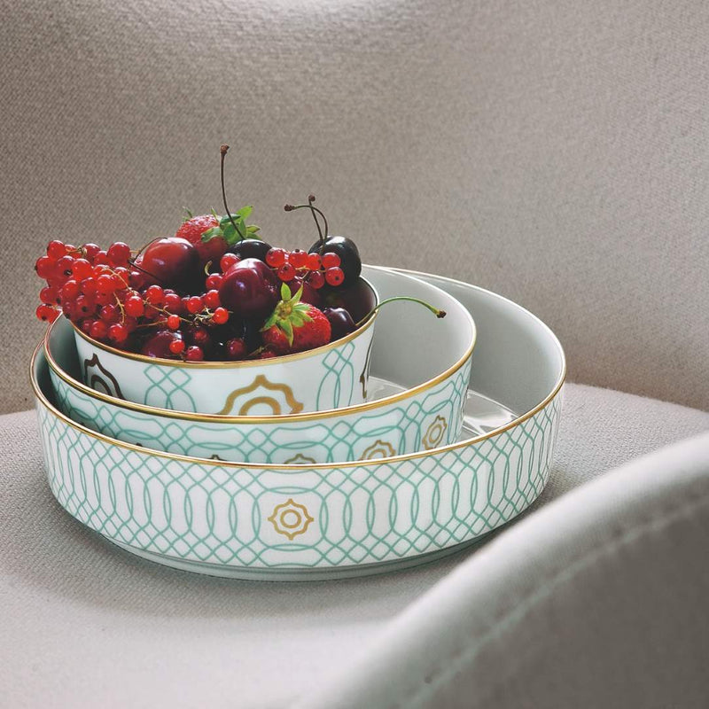 Decorative porcelain bowls from Carlo Este collection with berries on a neutral background