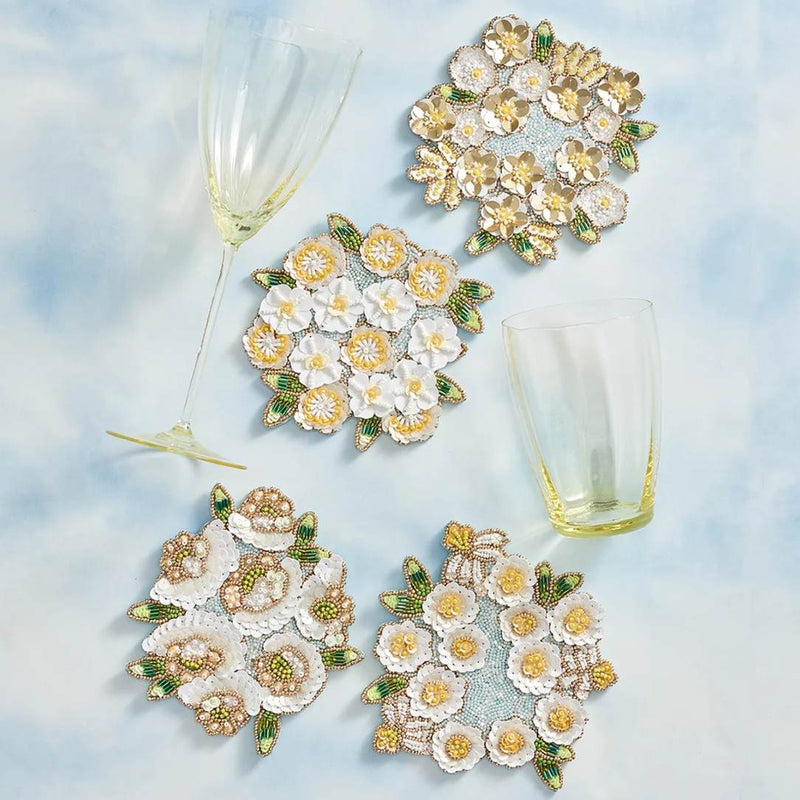 Set of floral coasters on a light blue background with glasses.