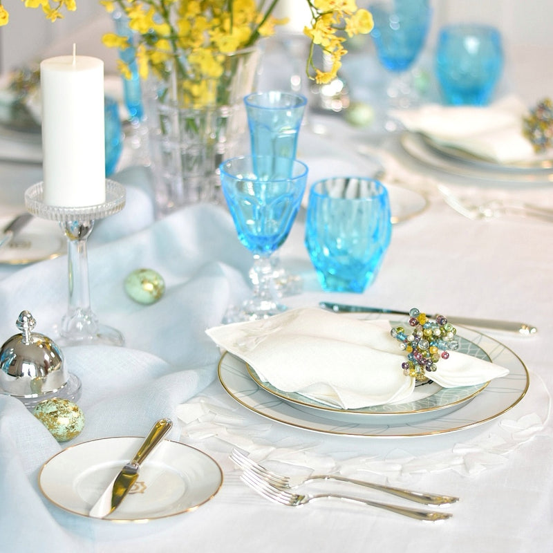 white table linen with blue glasses and napkin ring