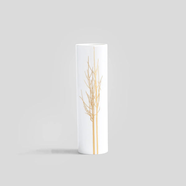Cylindrical white vase with gold tree branch design on a light gray background