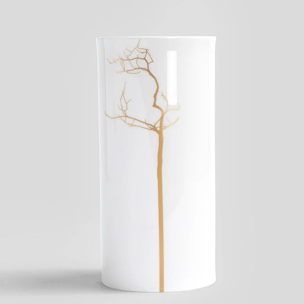White vase with gold tree branch design on a light gray background