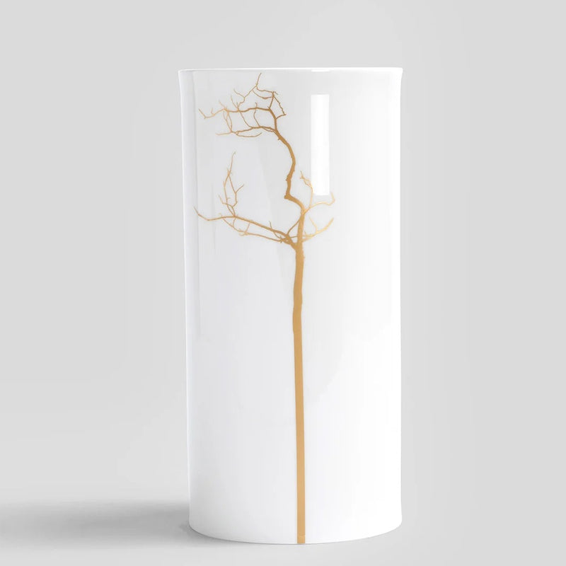 White vase with gold tree branch design on a light gray background