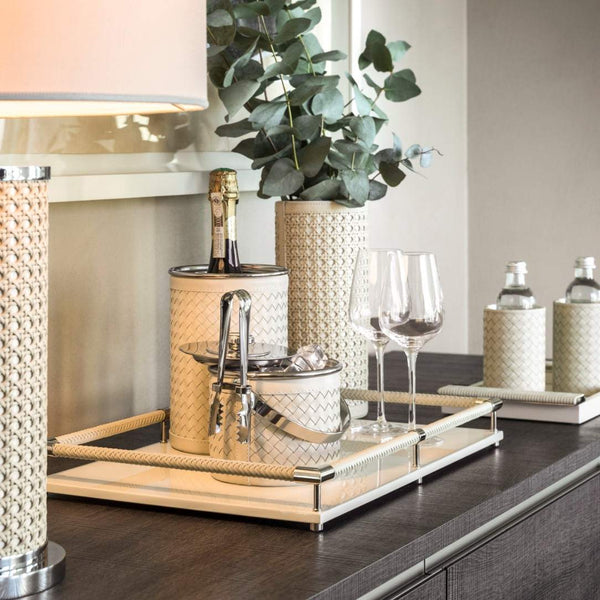 Decorative setting with champagne, glasses, and Luxury handwoven leather ice bucket with lid by Riviere x Giobagnara