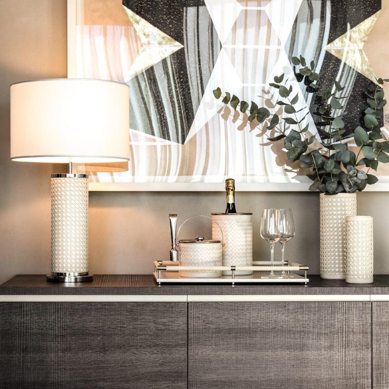 Decorative setting with table lamps, wine glasses, and dLuxury handwoven leather ice bucket with lid by Riviere x Giobagnara