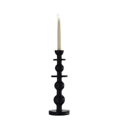 Black candle holder with a white candle on a white background