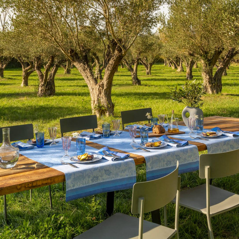 garden with olive trees featuring a decorated table with blue linen 