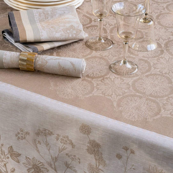 Dining table setting with floral-patterned tablecloth, glasses, and napkins.