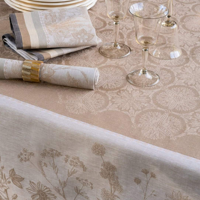 Dining table setting with floral-patterned tablecloth, glasses, and napkins.