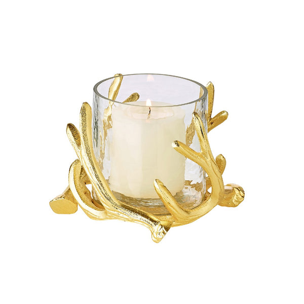 A gold-colored candle holder with deer antlers as a decorative element, featuring a clear glass bowl to hold a candle.