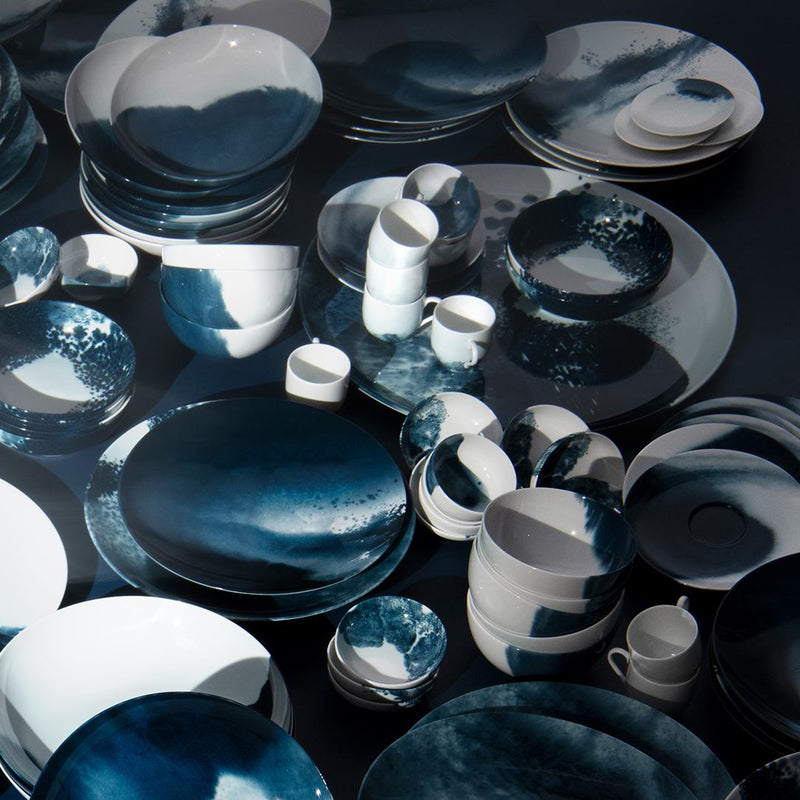 Collection of Ocean-inspired porcelain crockery Abysses by Raynaud on a dark surface